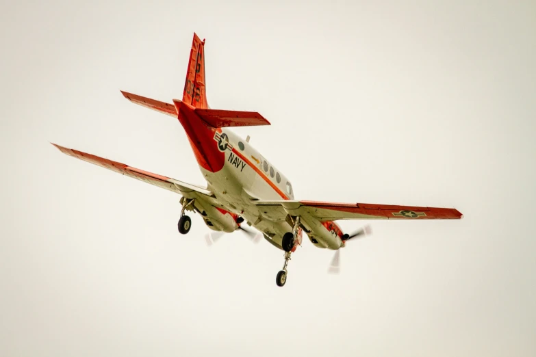 a red and white plane flying against a white background