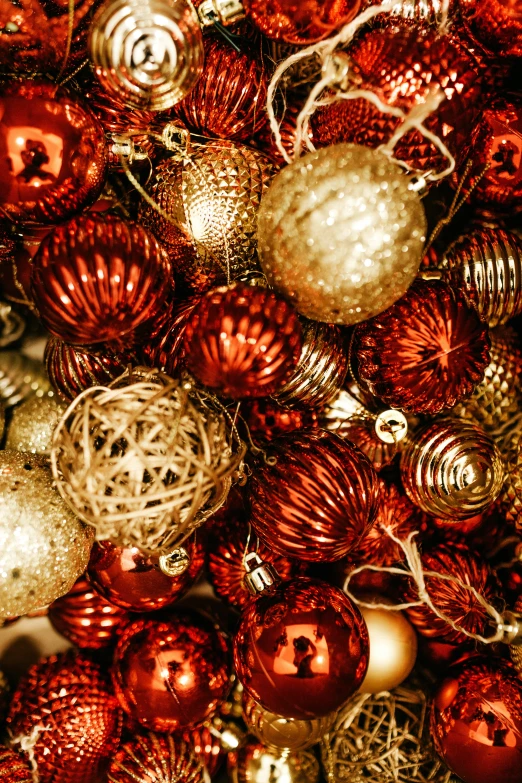 many shiny christmas ornaments, in orange and gold tones