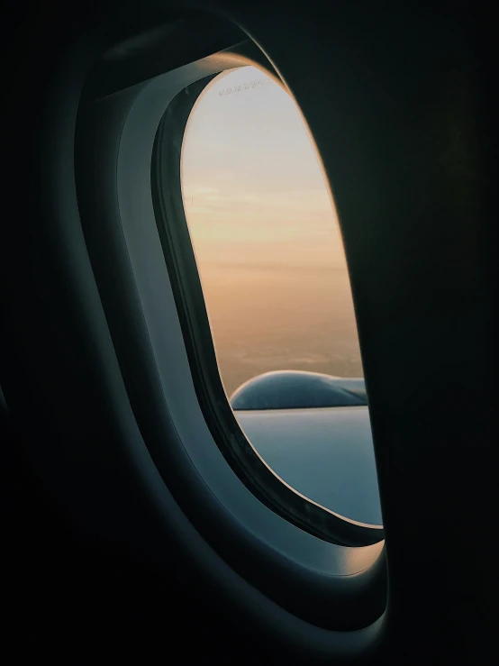 an airplane window with the view of a snowy landscape