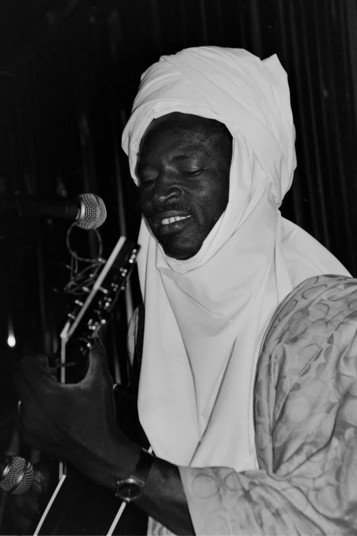 a person with a scarf around their head holding a microphone