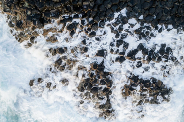 the top view of a rocky shoreline with blue water