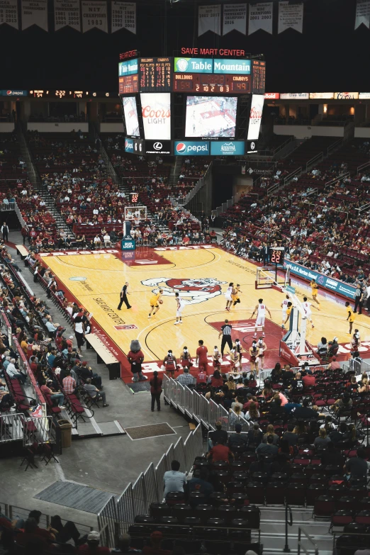 a basketball court with people playing and a few watching