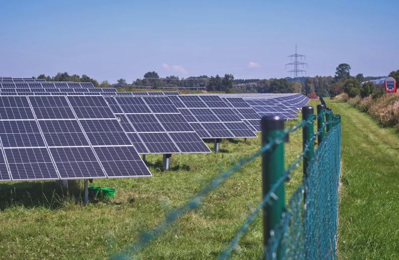 many large solar panels sit together on the grass