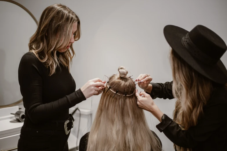 two women with hats combing their hair in the bathroom