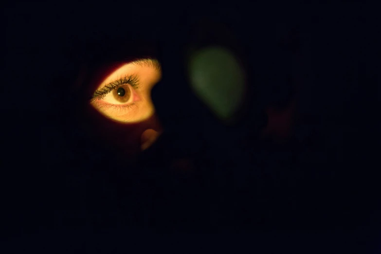 the side view of an eye of a woman with long, brown hair