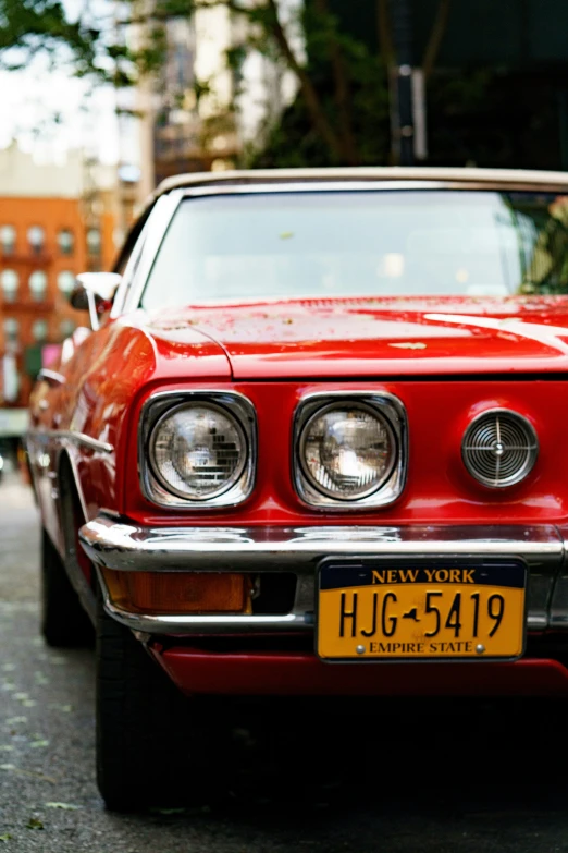 a red car parked in front of a large building