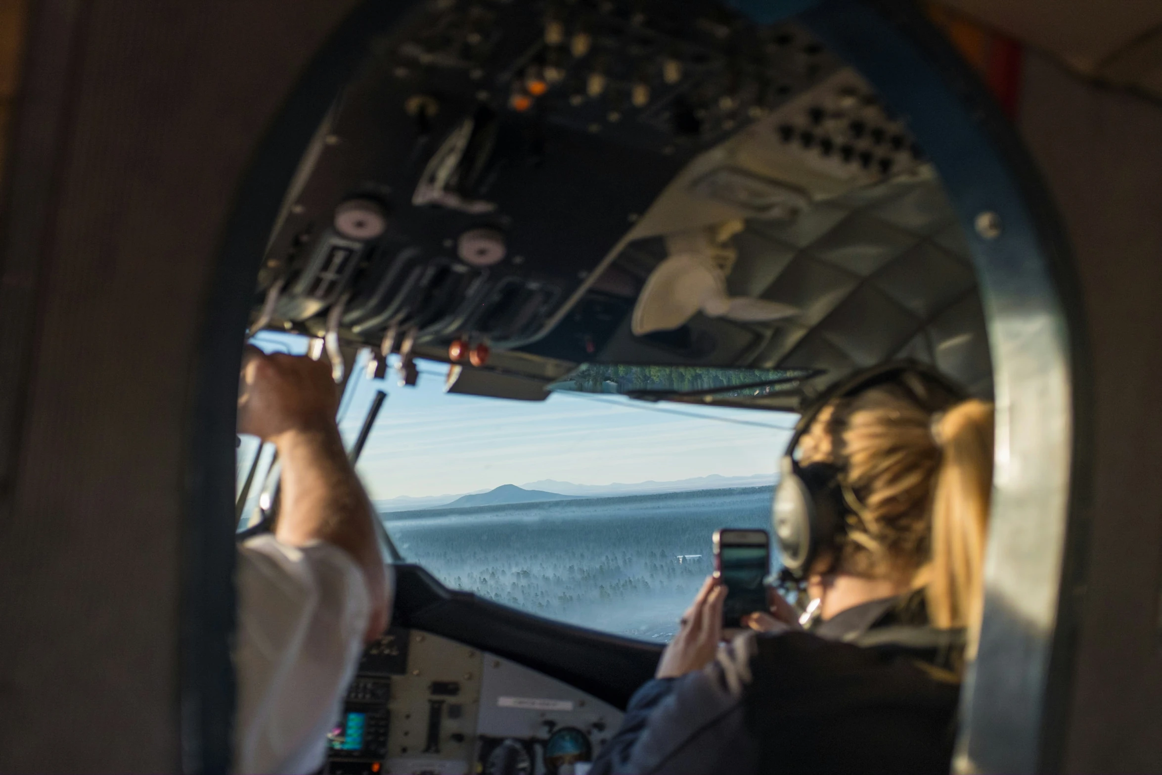 two people in a cockpit looking out from the plane