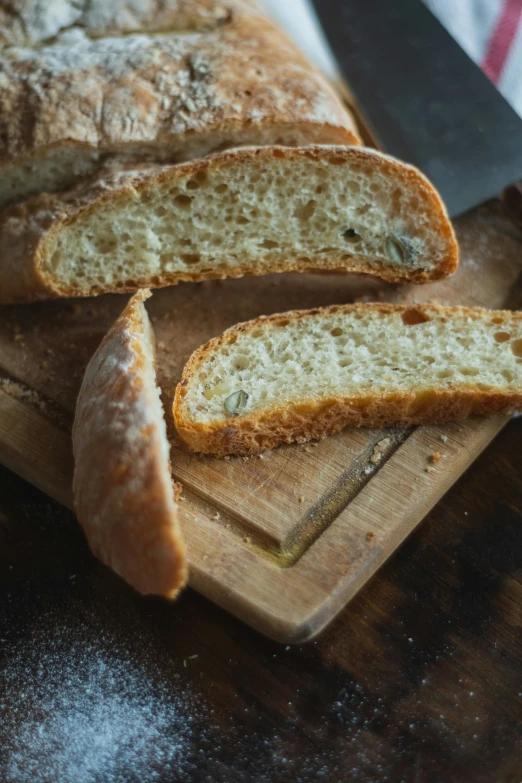 a loaf of bread sits on a  board next to a knife