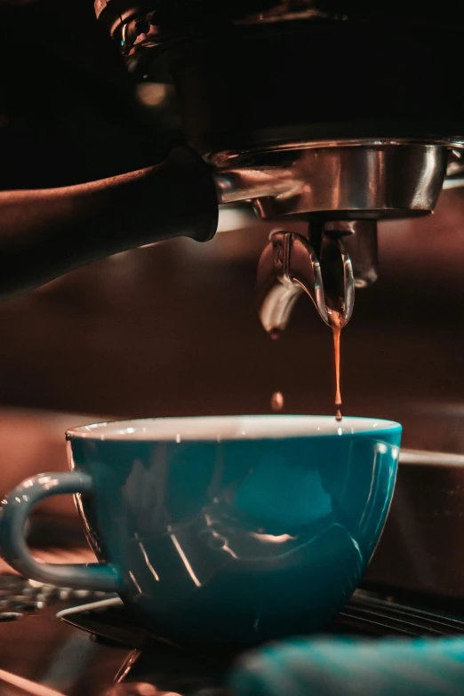 coffee being poured into a blue ceramic cup