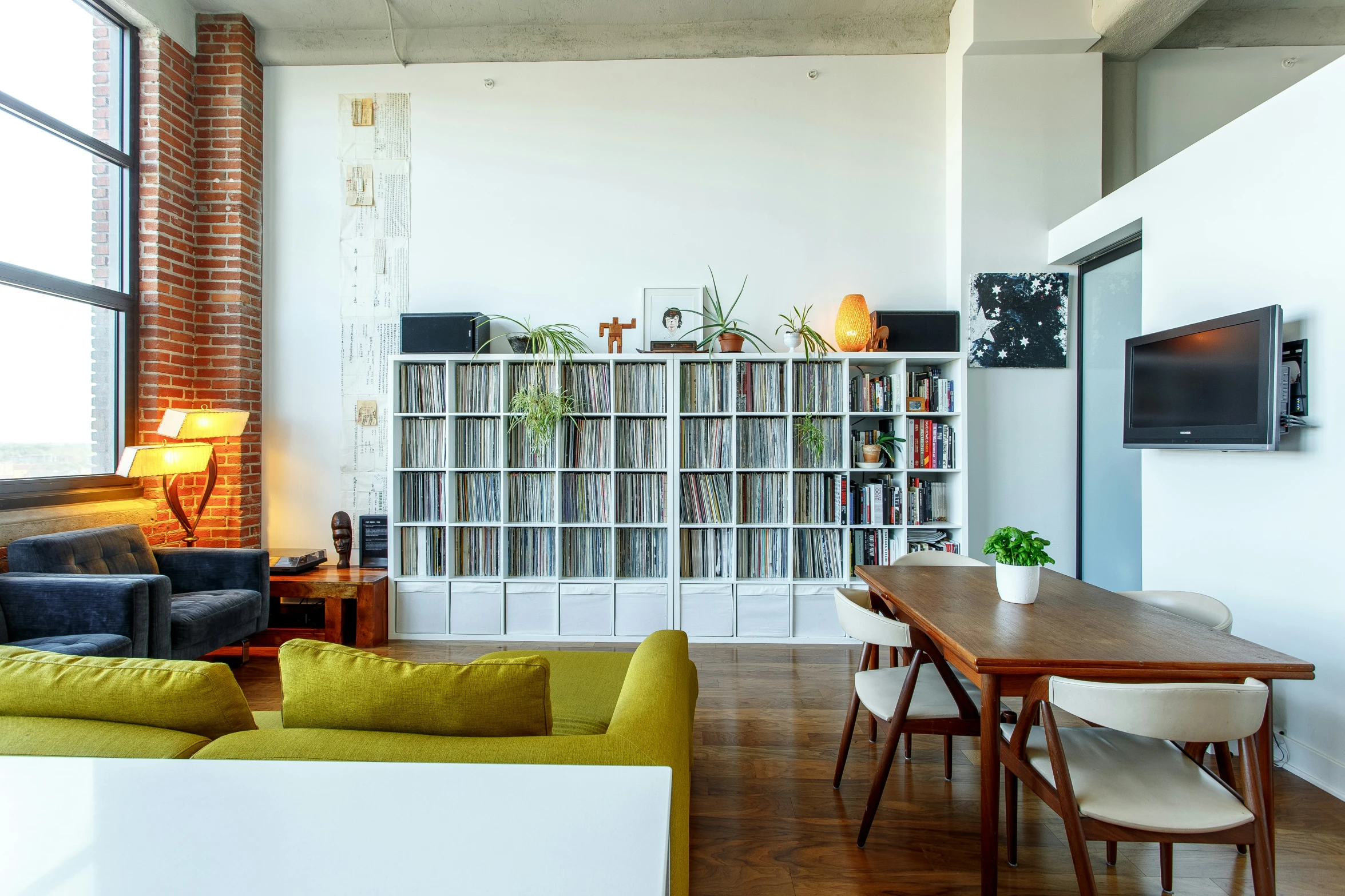 a room with wood floors and large windows