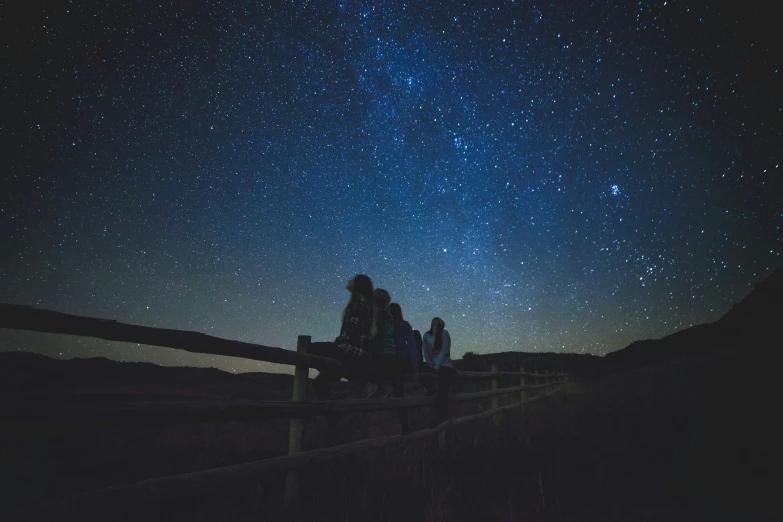people sitting on a bench under the stars