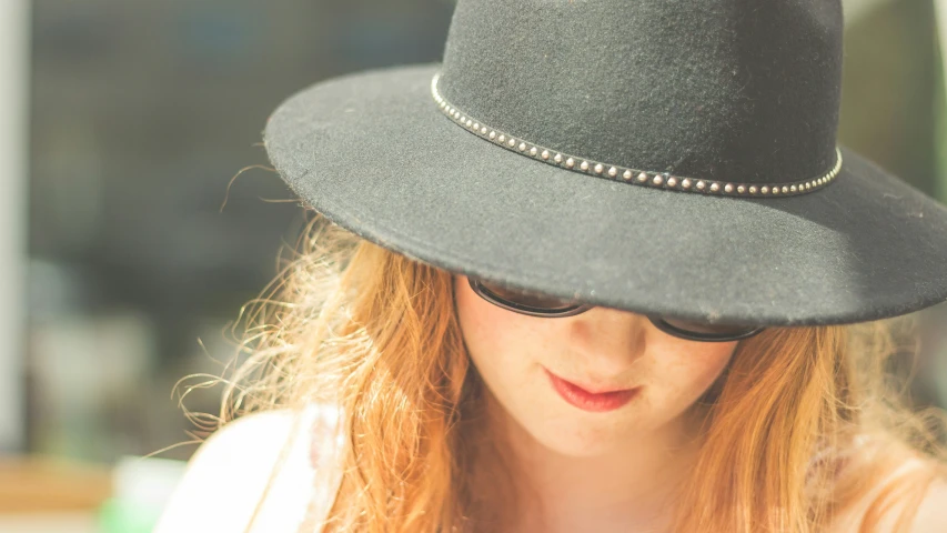 a woman wearing a black hat and glasses