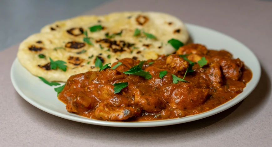 a plate full of food with roti bread