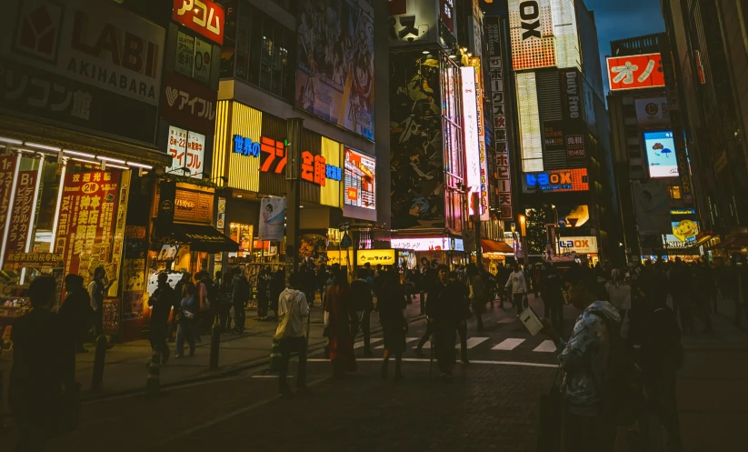 a city filled with people standing next to tall buildings