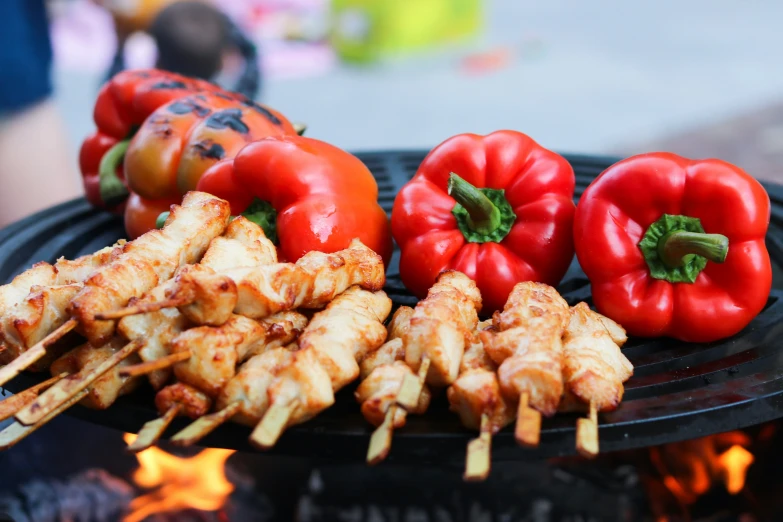 many different food items on skewers near fire