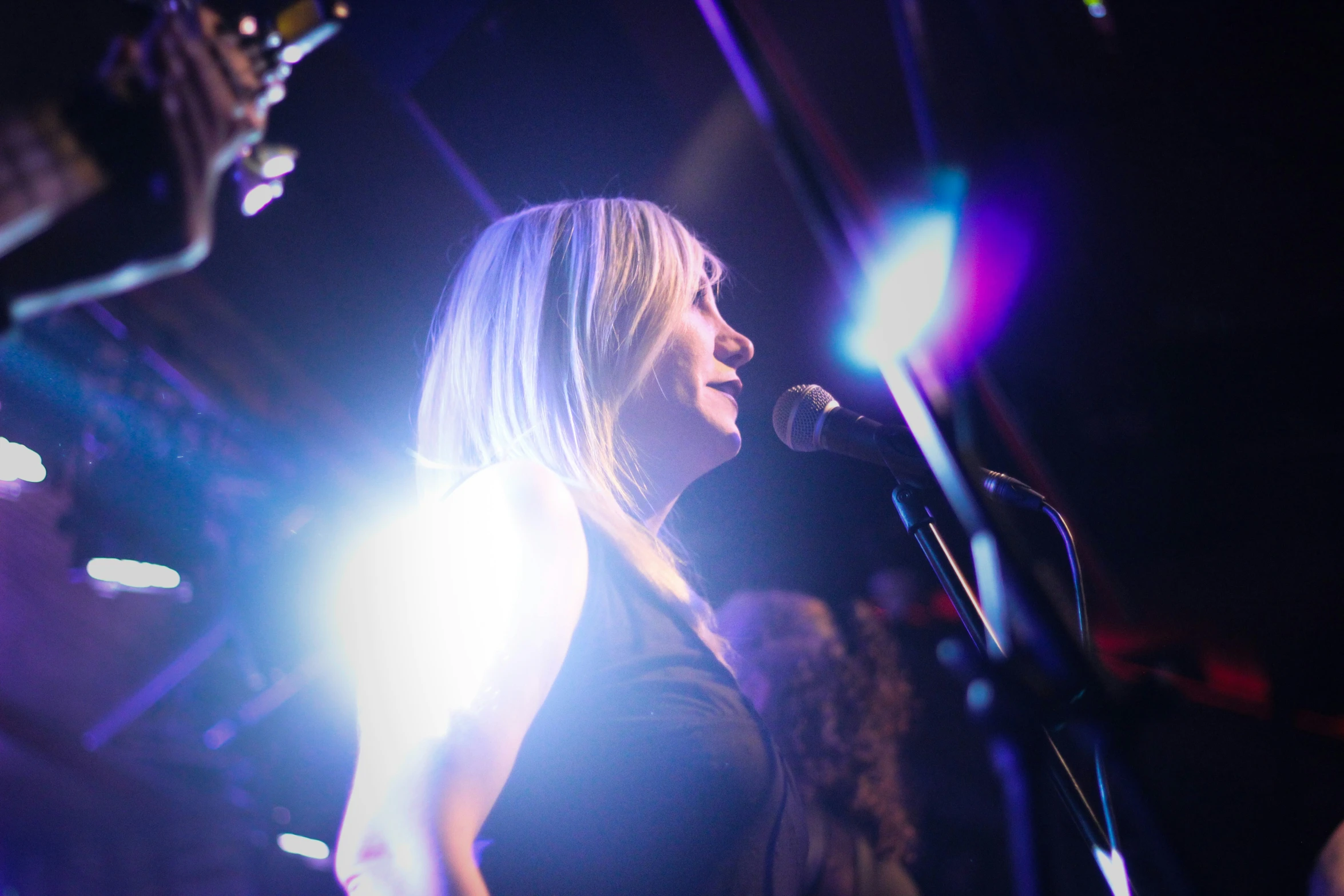 the woman is singing in front of a crowd