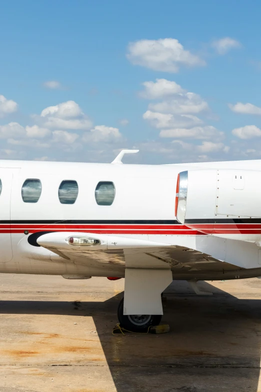 an airplane parked in a field next to a cloud filled sky