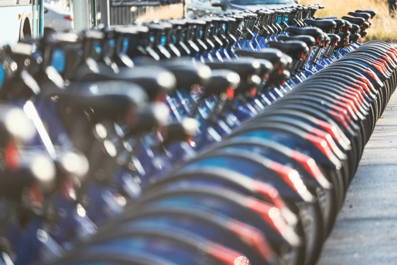 many bicycles parked on a long row by a building