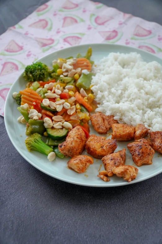 chicken, vegetables and rice are on the plate