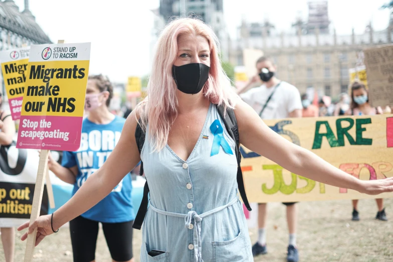 a woman in a black mask and some protest signs