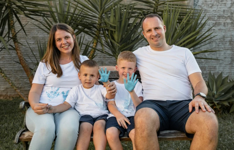 two adults and three children holding hands pose for a picture