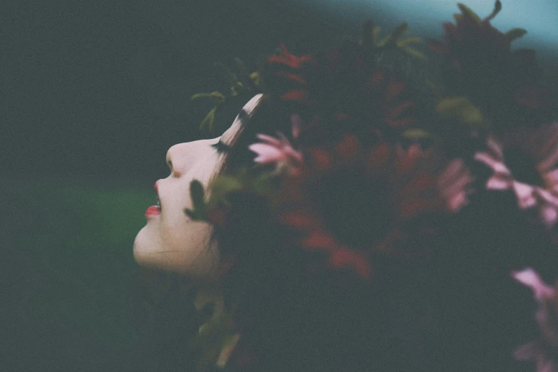 a girl with flowers in front of her face