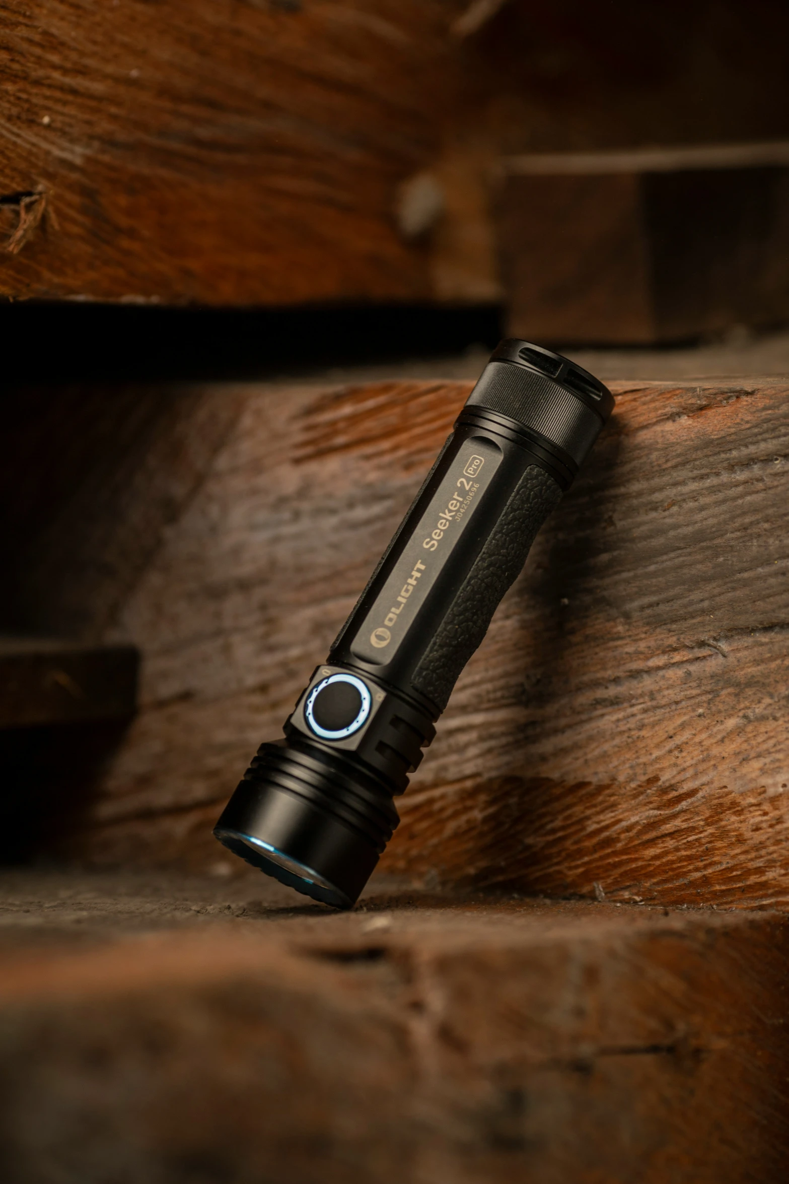 a close up image of a black flashlight on some wood