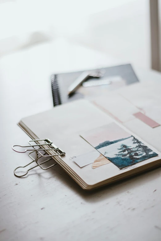 an open binder with metal clips on a white table