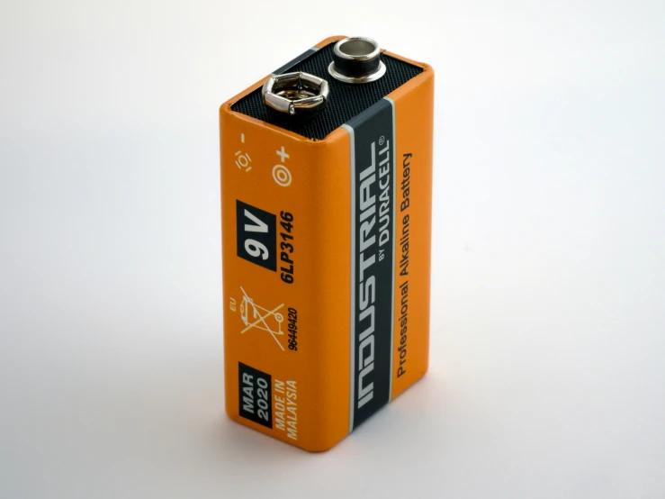 an orange battery on a white surface