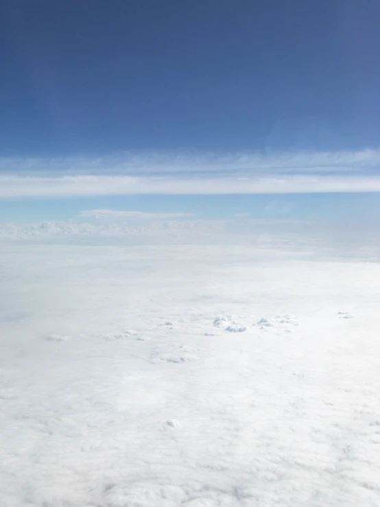 an aerial view of the sky showing clouds and distant land