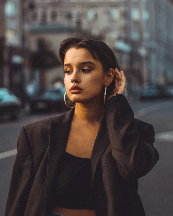 a woman in a black outfit standing near the side of a street