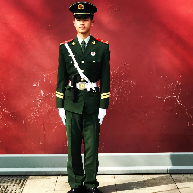 a soldier stands in front of a red background
