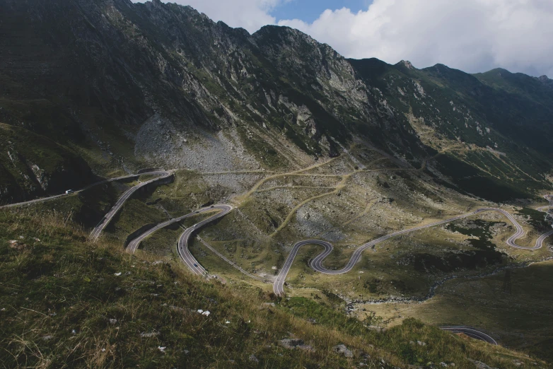 a winding mountain road through some grass