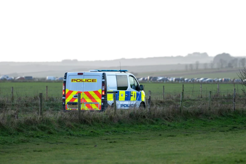 the police car is parked near a fence