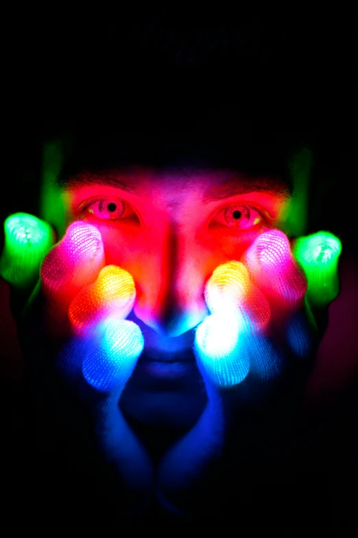 a close up of someone's face with glowing fingers and hands