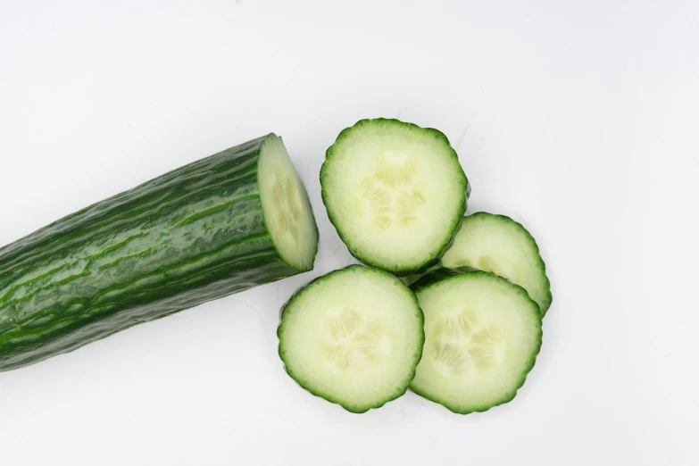 cucumbers on a white surface ready to be cut in half