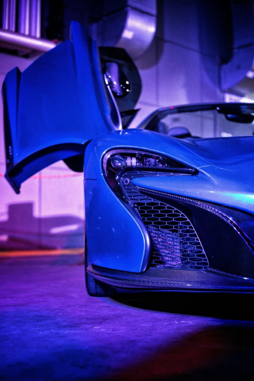 a close up of a blue sports car in the process of being painted