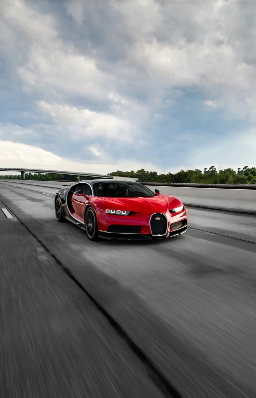 a red sports car driving down an overpass