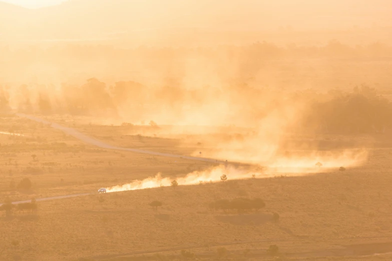 a group of cars blowing up dirt in the air