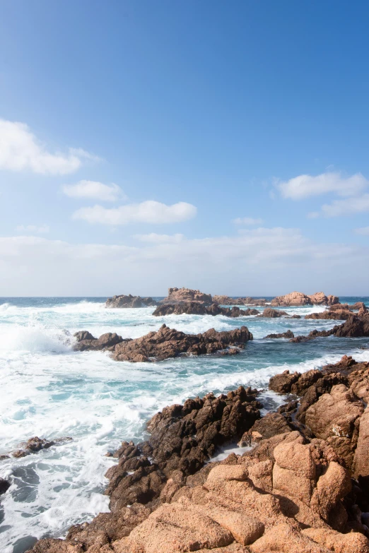 a rocky shore next to a body of water with rocks