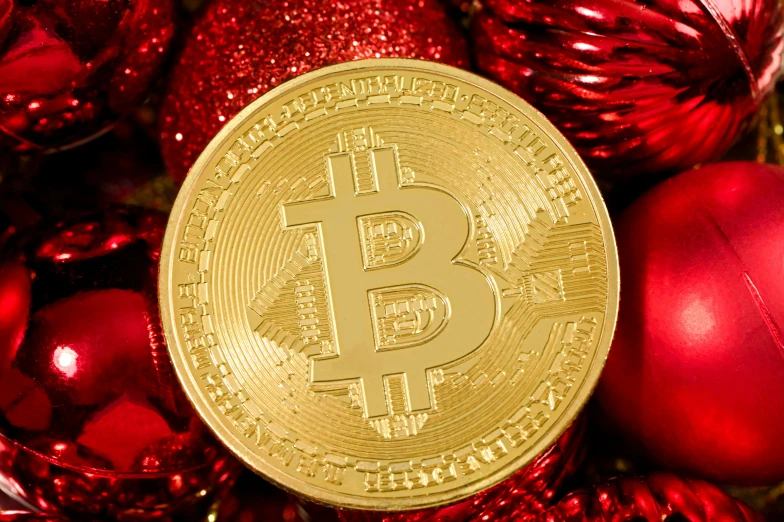 a gold bit coin sitting atop a pile of ornaments