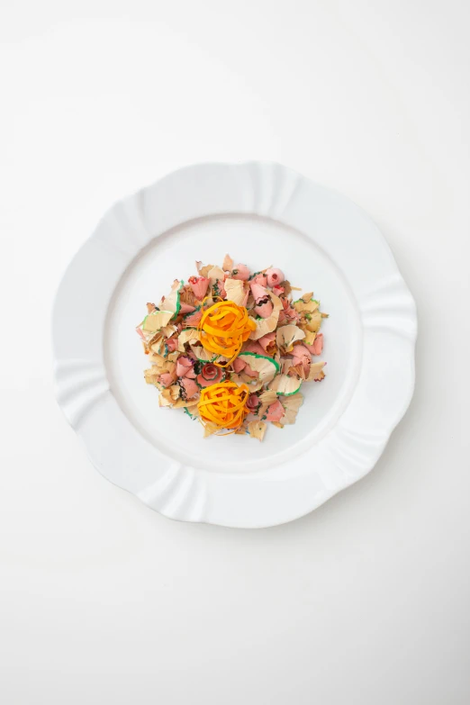 white plate filled with lots of flowers and a flower on top