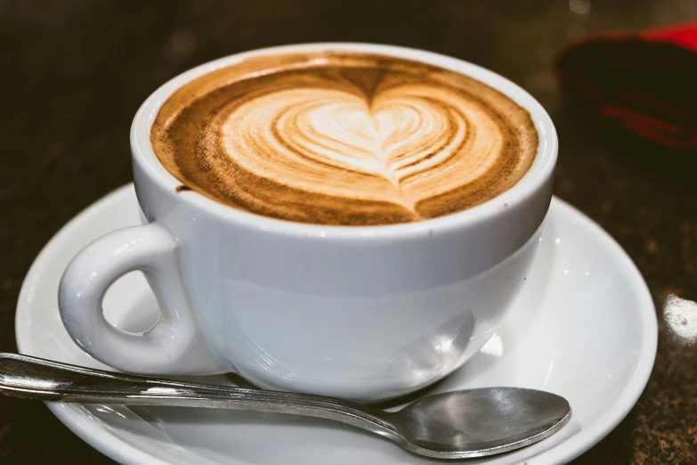a cup with latte art sits on a saucer