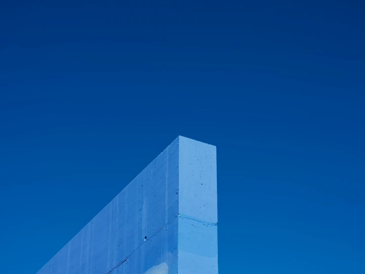 an airplane flies in the blue sky above the building