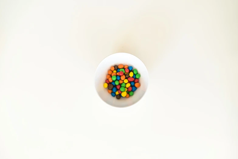 a small bowl with colored candy in it