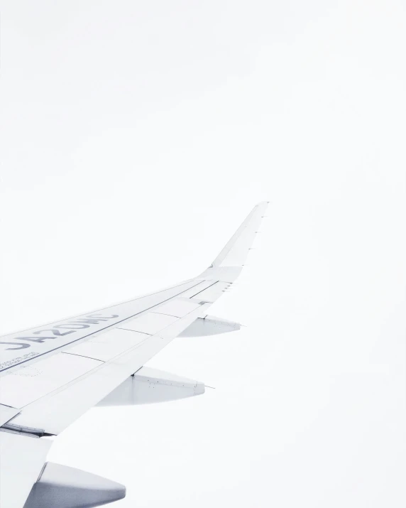 the airplane flies in the sky in front of a cloud