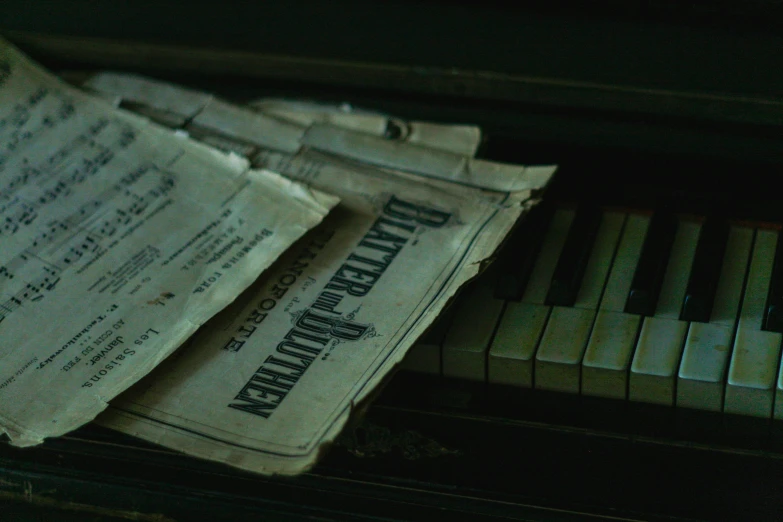 newspapers are stacked on top of a piano