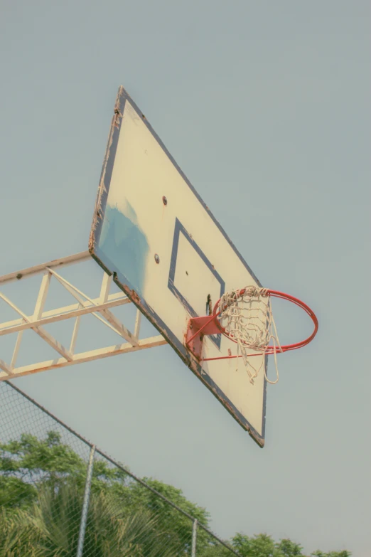 a basketball hoop hanging from the side of a fence