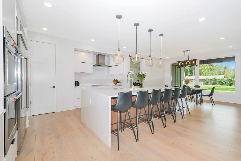 an expansive white kitchen and bar area features wooden floors