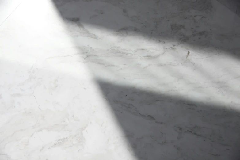 a marble floor with the sunlight coming through the window